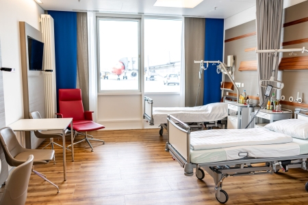 Ein Krankenhauszimmer mit Blick auf ein Flugzeug.