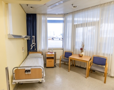 Ein Krankenhauszimmer mit Blick auf den Flughafen.